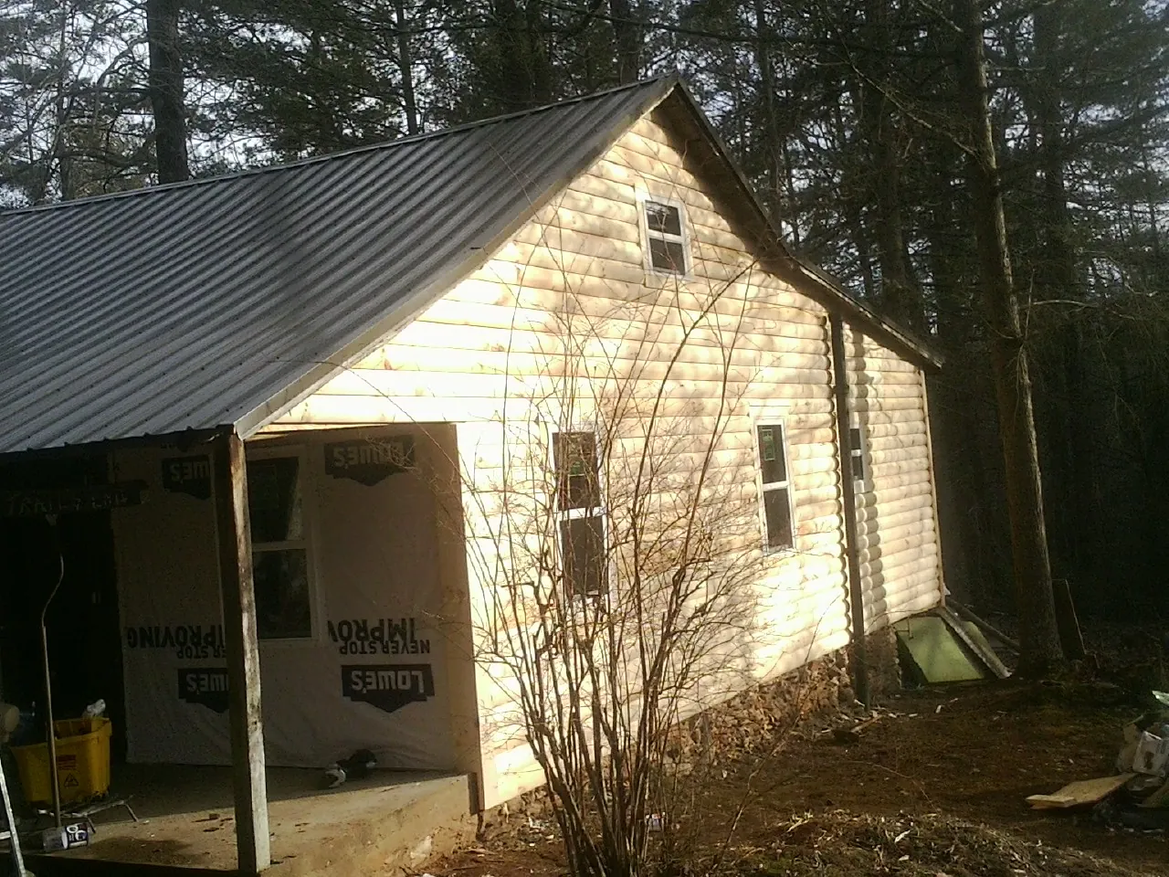 Log siding gable end under a dark metal roof edge in Bogalusa