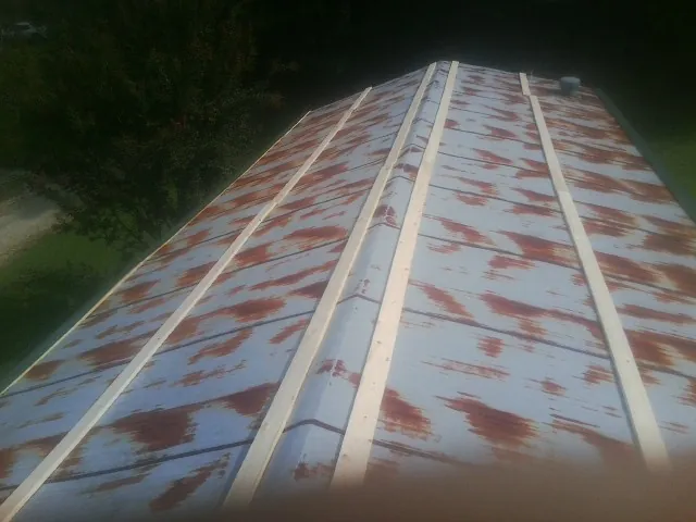 Rusted metal roof panels with new wood purlins before replacement — Storm Damage Roof Repair in Bogalusa by Roofing Brothers