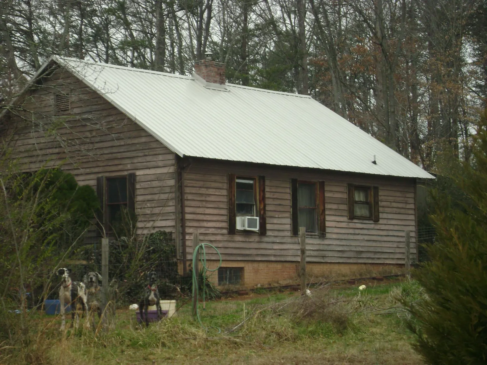 White metal roof on an old wood sided farmhouse, from a Metal Roof Installation job in Bogalusa